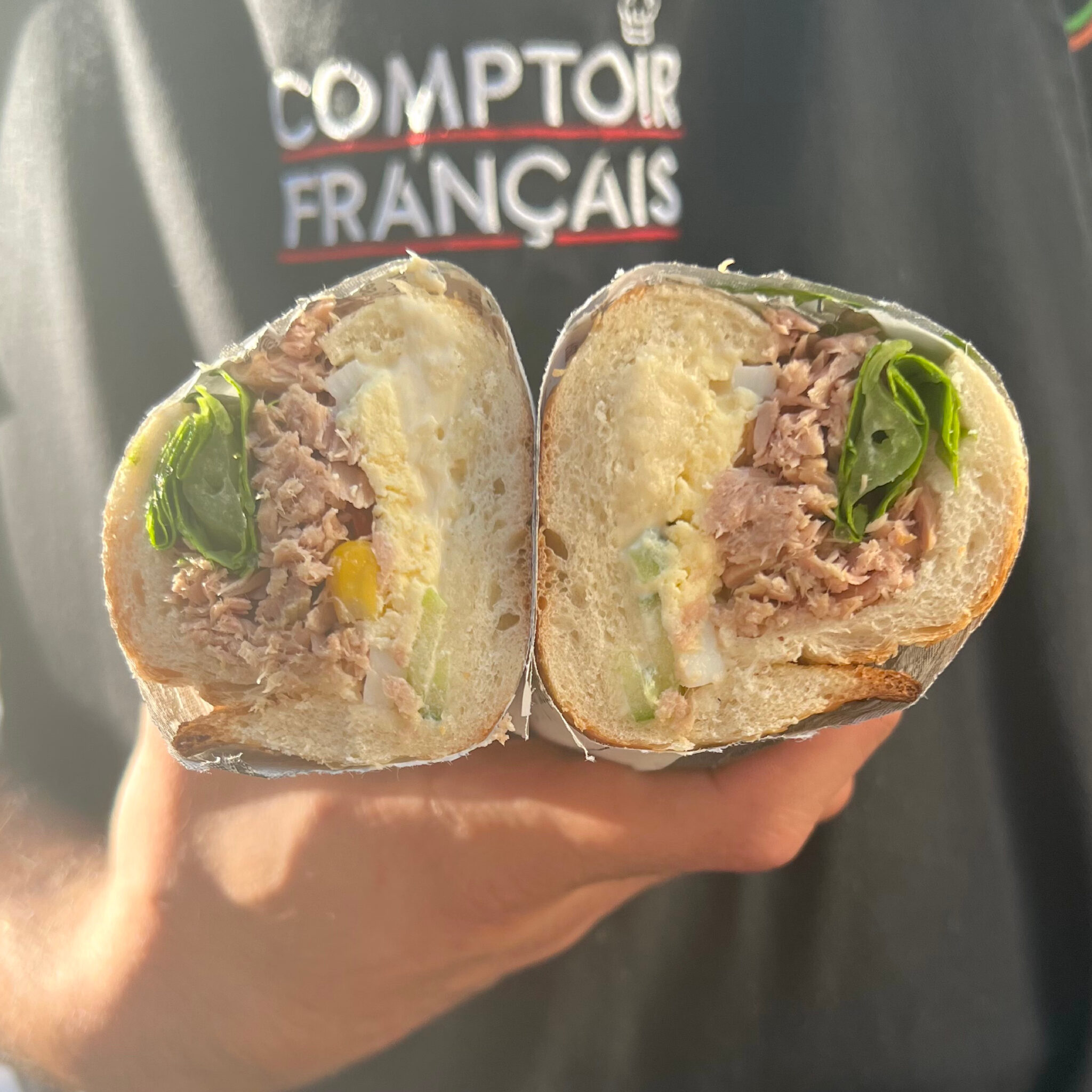 Sandwich au thon mayonnaise, œuf et salade verte, coupé en deux